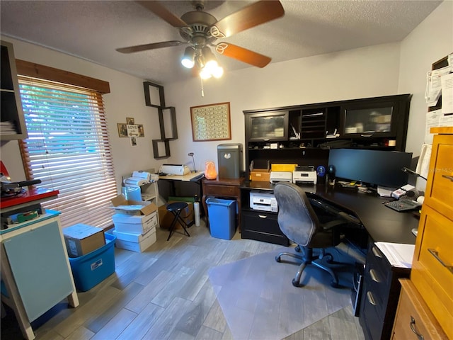 office space featuring ceiling fan, a textured ceiling, and light hardwood / wood-style flooring