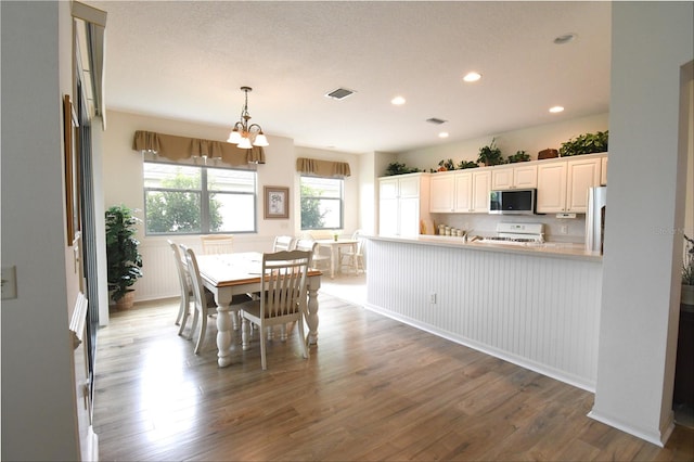 dining space with hardwood / wood-style floors and an inviting chandelier