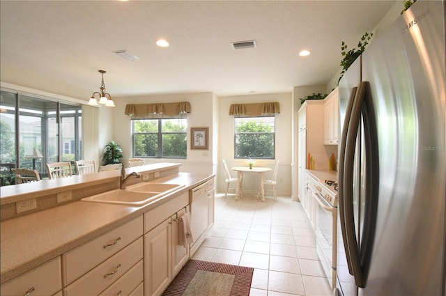 kitchen featuring light tile patterned flooring, a notable chandelier, decorative light fixtures, white appliances, and sink