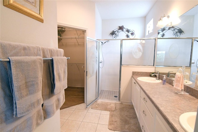 bathroom featuring double vanity, an enclosed shower, and wood-type flooring