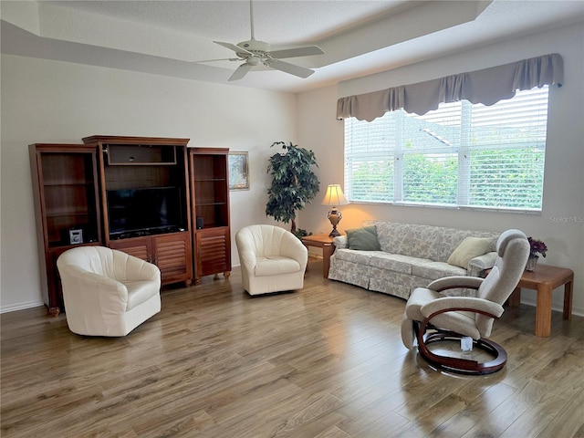 living room featuring ceiling fan, wood-type flooring, and a wealth of natural light