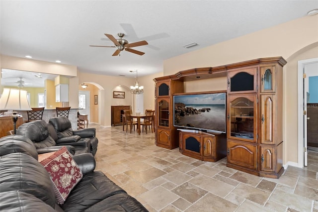 living room featuring ceiling fan with notable chandelier