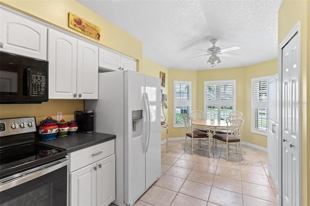 kitchen with white fridge with ice dispenser, light tile patterned flooring, white cabinetry, stainless steel range with electric stovetop, and ceiling fan