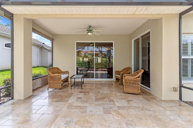 sunroom / solarium featuring ceiling fan and beamed ceiling