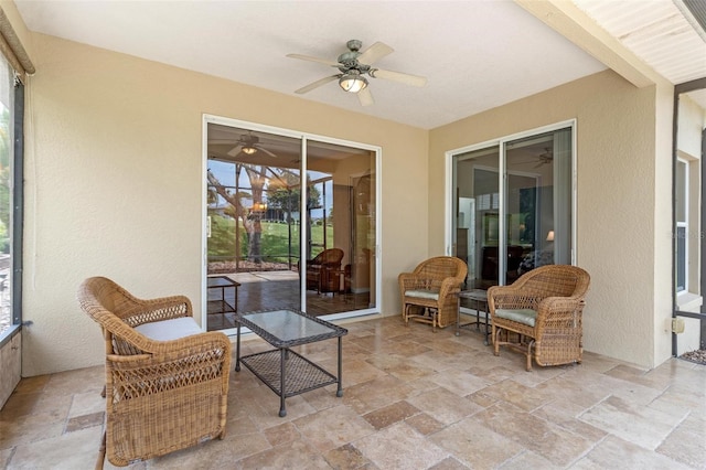 sunroom featuring ceiling fan and beam ceiling