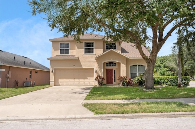 view of front of home featuring cooling unit, a garage, and a front yard