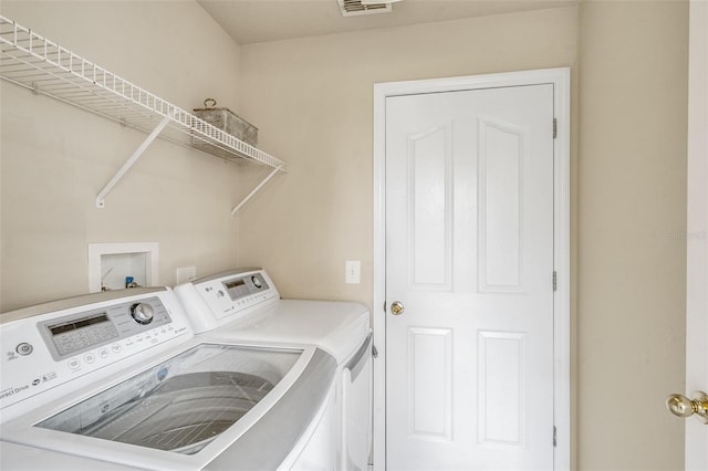 clothes washing area with washing machine and dryer