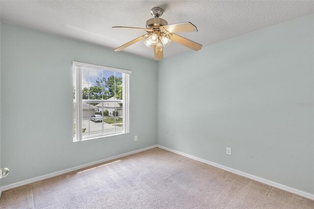 carpeted spare room featuring a textured ceiling and ceiling fan