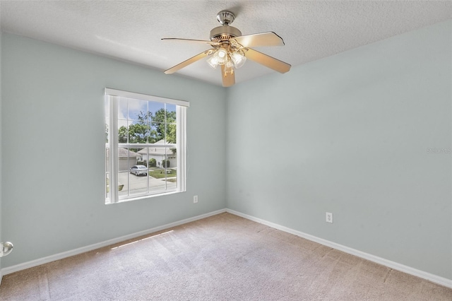 carpeted empty room featuring ceiling fan and a textured ceiling