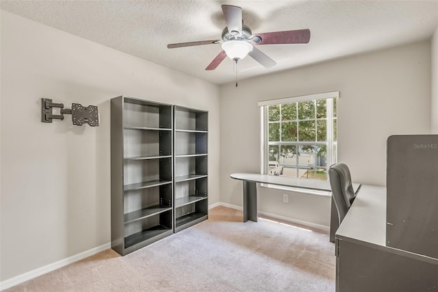 home office featuring light colored carpet, a textured ceiling, and ceiling fan