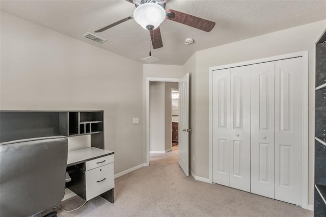 carpeted office space featuring ceiling fan and a textured ceiling