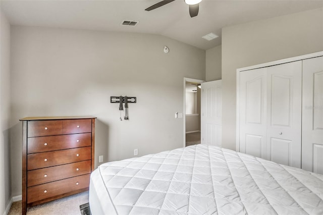 bedroom featuring vaulted ceiling, a closet, ceiling fan, and light colored carpet