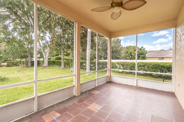 unfurnished sunroom with ceiling fan