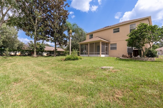 rear view of house with a sunroom and a lawn