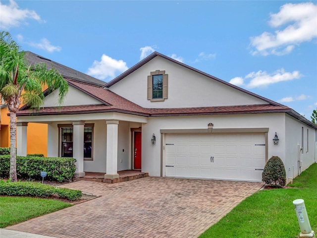 view of front of house featuring decorative driveway, stucco siding, a porch, a garage, and a front lawn