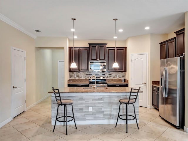 kitchen featuring backsplash, appliances with stainless steel finishes, a kitchen breakfast bar, and decorative light fixtures