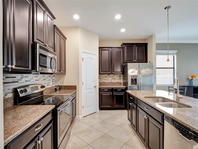 kitchen with tasteful backsplash, light tile patterned floors, hanging light fixtures, appliances with stainless steel finishes, and sink