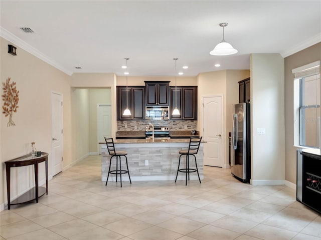 kitchen with stainless steel appliances, a kitchen breakfast bar, decorative light fixtures, and ornamental molding