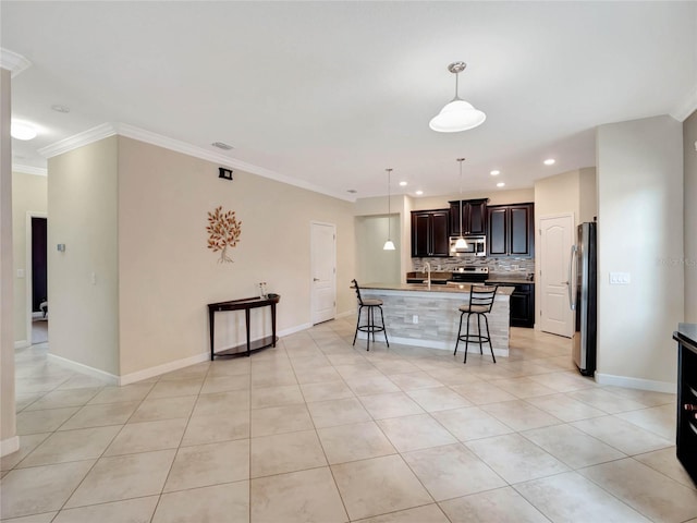 kitchen with crown molding, stainless steel appliances, decorative backsplash, a kitchen breakfast bar, and a center island with sink