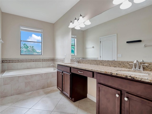 bathroom with plenty of natural light, tiled tub, dual vanity, and tile patterned floors