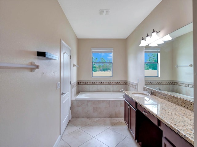 bathroom featuring tiled bath, tile patterned floors, and vanity