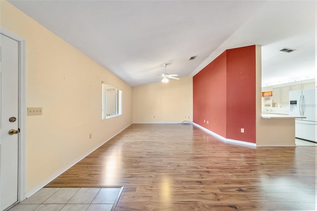 unfurnished living room with ceiling fan, light wood-type flooring, and vaulted ceiling