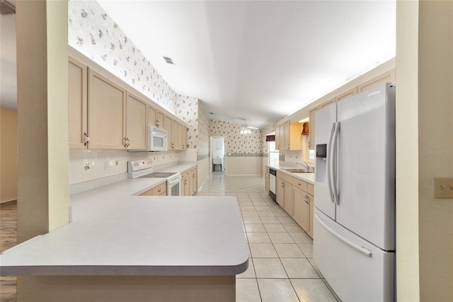 kitchen featuring kitchen peninsula, white appliances, light brown cabinetry, and light tile patterned floors