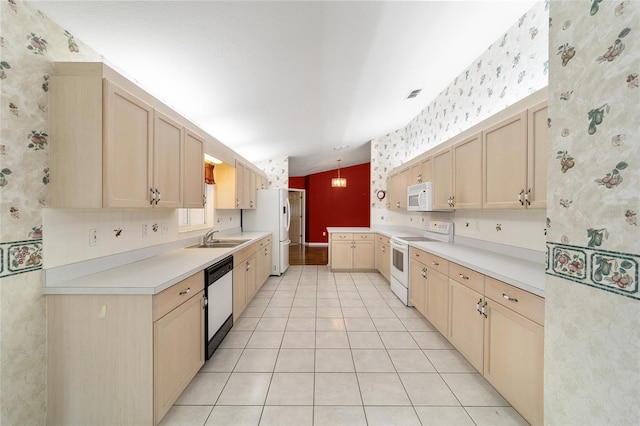 kitchen featuring white appliances, light tile patterned floors, sink, pendant lighting, and light brown cabinetry