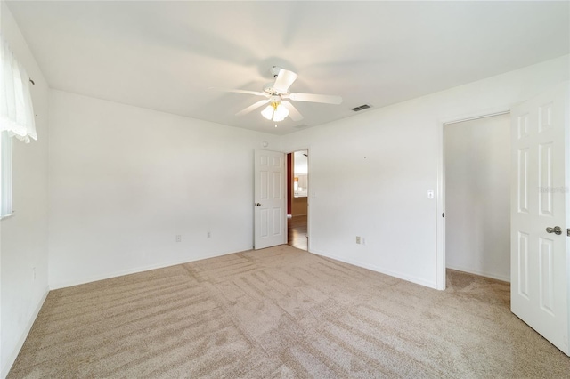 carpeted spare room with ceiling fan