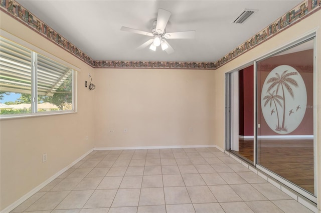 tiled spare room with ceiling fan