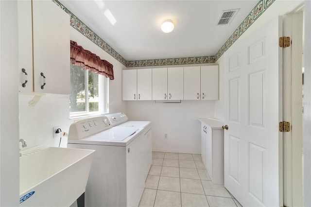 clothes washing area with light tile patterned flooring, sink, separate washer and dryer, and cabinets