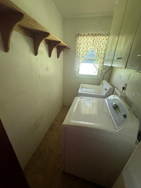 clothes washing area featuring dark tile patterned floors and separate washer and dryer