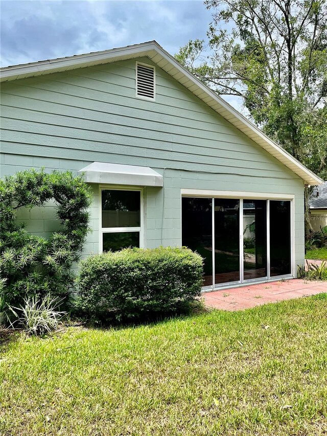 rear view of property featuring a lawn