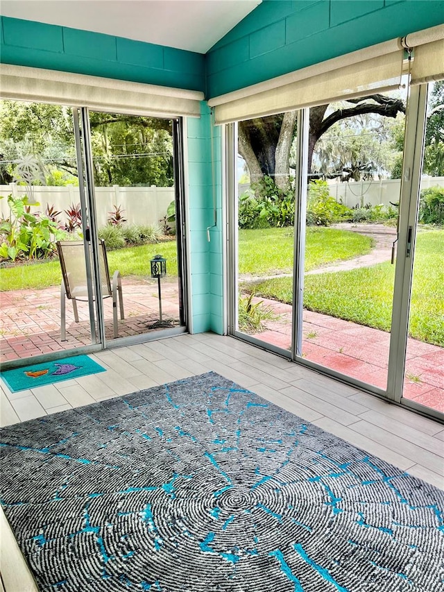 unfurnished sunroom featuring lofted ceiling and a wealth of natural light