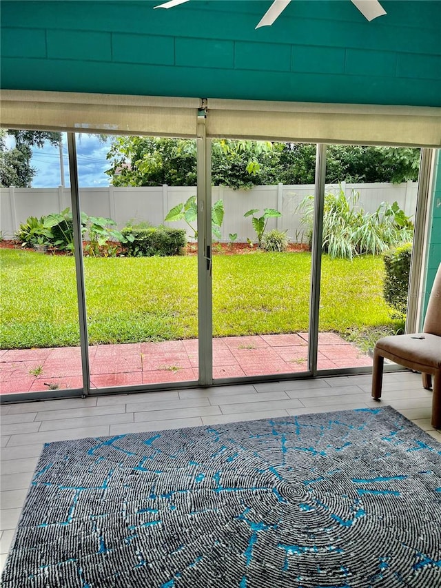 unfurnished sunroom with ceiling fan