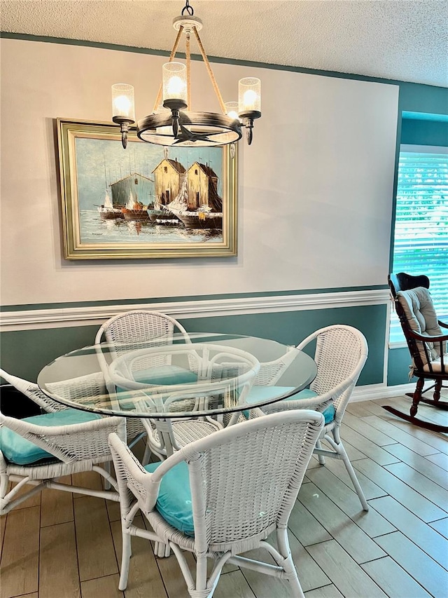 dining space with a textured ceiling and hardwood / wood-style flooring