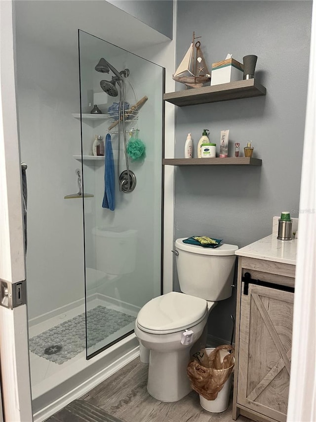 bathroom with toilet, an enclosed shower, vanity, and wood-type flooring