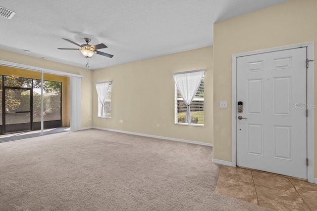 carpeted entryway with ceiling fan