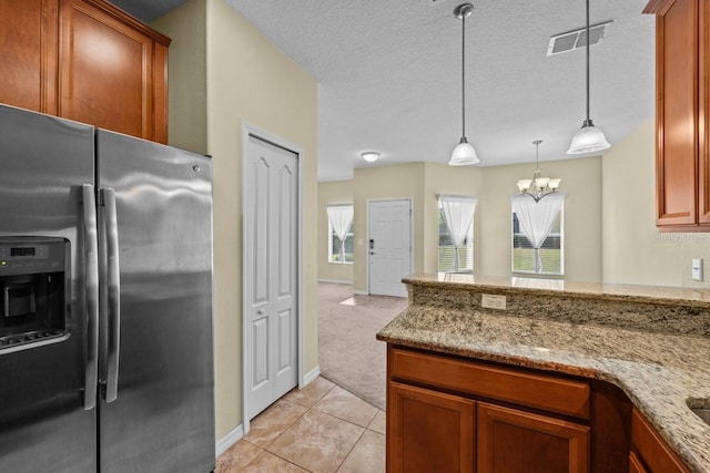 kitchen featuring stainless steel fridge with ice dispenser, light stone counters, pendant lighting, and light carpet