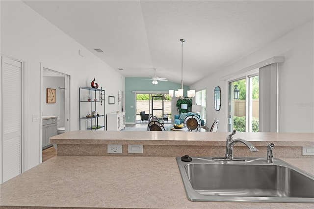 kitchen featuring a healthy amount of sunlight, sink, pendant lighting, and vaulted ceiling