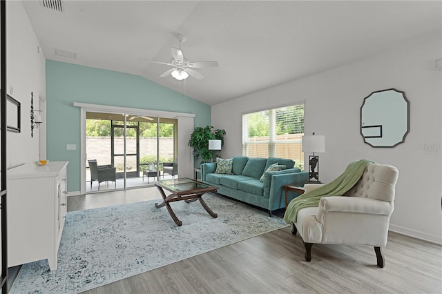 living room featuring ceiling fan, light wood-type flooring, vaulted ceiling, and a wealth of natural light