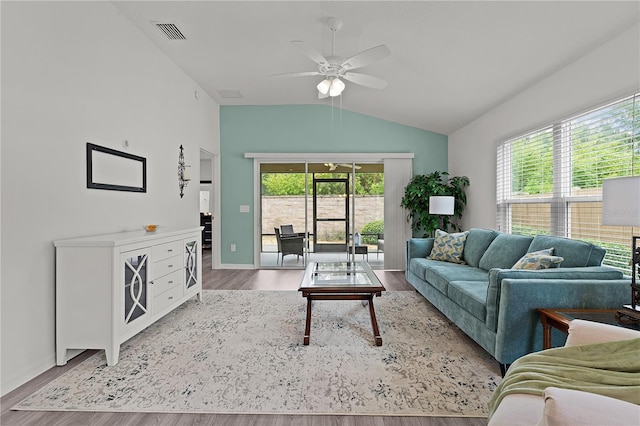 living room with lofted ceiling, hardwood / wood-style floors, and a wealth of natural light