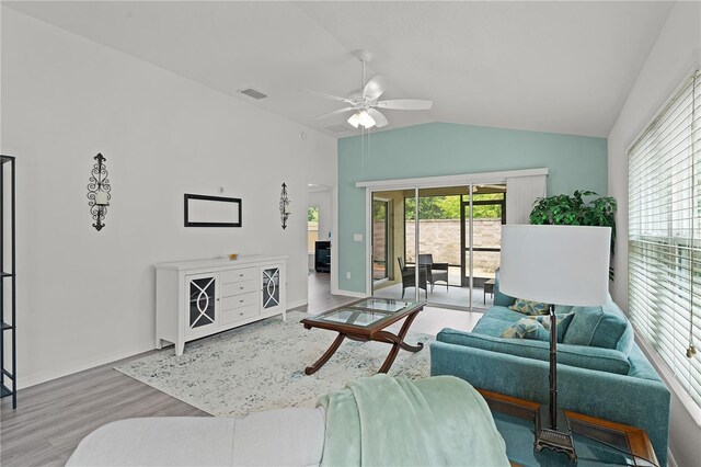 living room with vaulted ceiling, light wood-type flooring, and ceiling fan