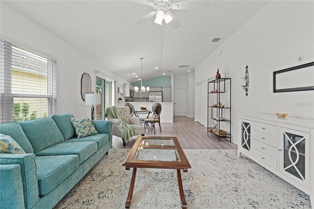 living room featuring lofted ceiling, light wood-type flooring, and ceiling fan