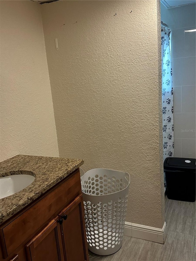 bathroom with vanity, curtained shower, and wood-type flooring