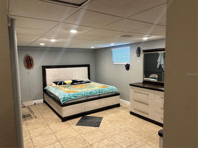 bedroom featuring a paneled ceiling and light tile patterned floors