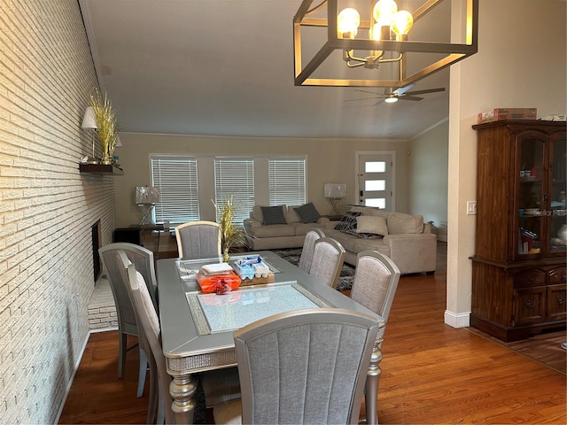 dining area featuring ornamental molding, ceiling fan with notable chandelier, and hardwood / wood-style floors