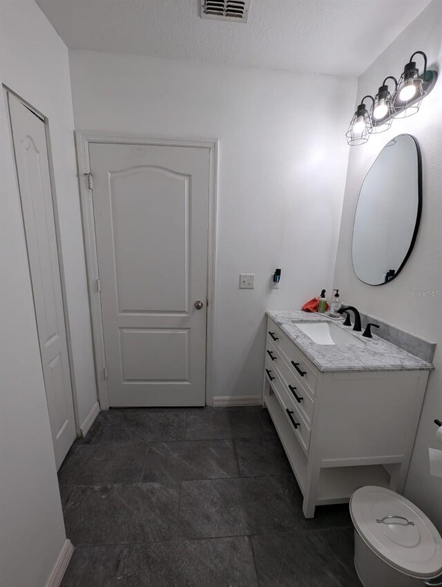 bathroom featuring vanity, tile patterned flooring, and toilet