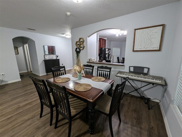 dining area with a textured ceiling and hardwood / wood-style flooring