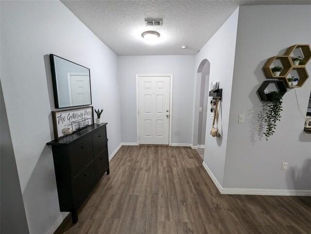 hall featuring a textured ceiling and hardwood / wood-style floors